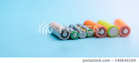 Rechargeable battery on blue background. Selective focus negative terminals of rechargeable lithium-ion batteries. AA and AAA size of old Li-ion battery. Battery recycling concept. Green power energy. 140640169
