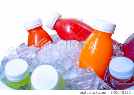 Organic cold pressed raw vegetable and fruit juice bottle in crushed ice bucket on white background. Healthy drink. Trendy juice beverage. Detox juice from fresh fruits and vegetables. Orange juice. Organic cold pressed raw vegetable and fruit juice bottle in crushed ice bucket on white background. Healthy drink. Trendy juice beverage. Detox juice from fresh fruits and vegetables. Orange juice. 140640182