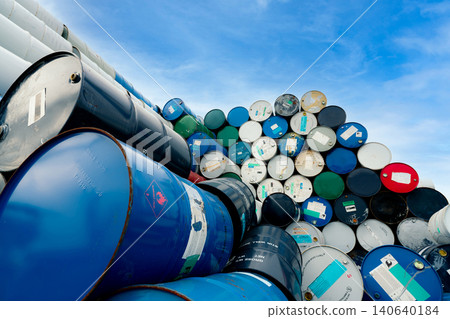 Old chemical barrels. Blue oil drum with flammable liquid symbol. Toxic waste warehouse. Hazard chemical tank with warning label. Industrial waste in drum. Stack of empty blue and red steel oil drum. Old chemical barrels. Blue oil drum with flammable liquid symbol. Toxic waste warehouse. Hazard chemical tank with warning label. Industrial waste in drum. Stack of empty blue and red steel oil drum. 140640184