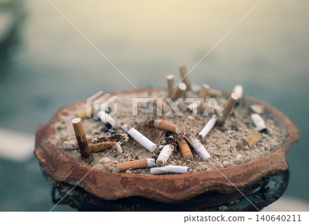Ashtray full of cigarette butts. Used cigarette in ashtray. Dirty cigarette filter waste in clay ashtray. Toxic waste. Quit smoke or smoking cessation and lung cancer trigger concept. Tobacco product. 140640211