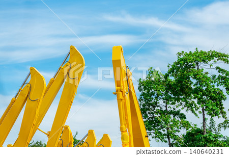 Selective focus on hydraulic piston arm of yellow backhoe on blur tree. Huge metal bulldozer. Excavator machine. Hydraulic machinery. Heavy machine industry. Mechanical engineering. Stock of backhoe. Selective focus on hydraulic piston arm of yellow backhoe on blur tree. Huge metal bulldozer. Excavator machine. Hydraulic machinery. Heavy machine industry. Mechanical engineering. Stock of backhoe. 140640231