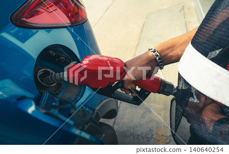 Car fueling at gas station. Refuel fill up with petrol gasoline. Petrol pump filling fuel nozzle in fuel tank of car at gas station. Petrol industry and service. Petrol price and oil crisis concept. Car fueling at gas station. Refuel fill up with petrol gasoline. Petrol pump filling fuel nozzle in fuel tank of car at gas station. Petrol industry and service. Petrol price and oil crisis concept. 140640254