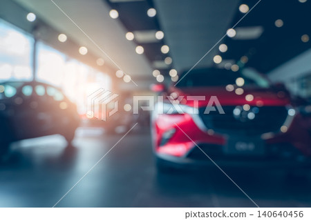 Blurred photo new red car parked in showroom. Car dealership office. Car parked in showroom with care. Car for sale and rent business. Automobile leasing market. Electric vehicle. Automotive industry. 140640456