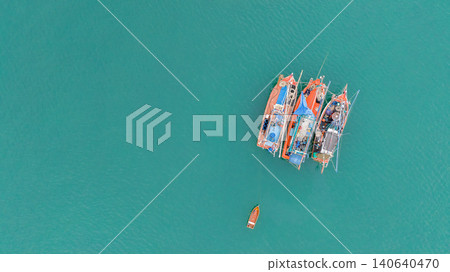 Aerial view of fishing boats anchored in turquoise tropical sea. Sustainable fishing. Traditional fishing. Maritime culture, sustainable fisheries and coastal life in a tropical destination. Aerial view of fishing boats anchored in turquoise tropical sea. Sustainable fishing. Traditional fishing. Maritime culture, sustainable fisheries and coastal life in a tropical destination. 140640470