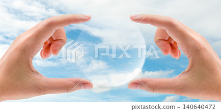 Hands protecting transparent globe against blue sky with white clouds, environmental conservation concept. Human responsibility for sustainability, climate protection and future ecosystem preservation Hands protecting transparent globe against blue sky with white clouds, environmental conservation concept. Human responsibility for sustainability, climate protection and future ecosystem preservation 140640472