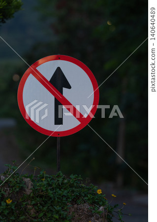 Prohibited straight ahead traffic sign on roadside with clear regulatory symbol, transportation safety concept showing road restriction and compliance with traffic rules in outdoor environment. Prohibited straight ahead traffic sign on roadside with clear regulatory symbol, transportation safety concept showing road restriction and compliance with traffic rules in outdoor environment. 140640489