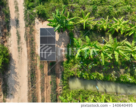 Solar panel powering irrigation system in rural farm with banana plantation and water canal, renewable energy supporting sustainable agriculture and reducing carbon emission. Agricultural field. Solar panel powering irrigation system in rural farm with banana plantation and water canal, renewable energy supporting sustainable agriculture and reducing carbon emission. Agricultural field. 140640495