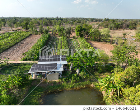 Aerial view of sustainable agriculture combining agroforestry, renewable solar power, irrigation pond and diverse food crops in tropical countryside for efficient land use management and resilience. Aerial view of sustainable agriculture combining agroforestry, renewable solar power, irrigation pond and diverse food crops in tropical countryside for efficient land use management and resilience. 140640521