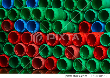 Used plastic barrels. Blue, green, and red plastic drum. Stacked of empty tank in food factory waiting for recycle and reuse. Container of raw material in food manufacturing industry. Old plastic drum Used plastic barrels. Blue, green, and red plastic drum. Stacked of empty tank in food factory waiting for recycle and reuse. Container of raw material in food manufacturing industry. Old plastic drum 140640552