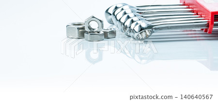 Metal hexagon nuts and chrome wrenches isolated on white background. Mechanic tools for maintenance. Hardware tool. Fastener with a threaded hole. Set chrome spanner wrench and nuts. Silver wrenches. Metal hexagon nuts and chrome wrenches isolated on white background. Mechanic tools for maintenance. Hardware tool. Fastener with a threaded hole. Set chrome spanner wrench and nuts. Silver wrenches. 140640567