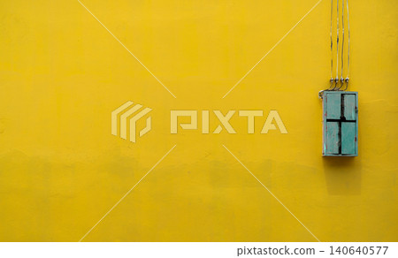 Green wooden box, electric control equipment in the factory on yellow vintage concrete wall background with copy space. Safety in home and factory industrial concept. Vintage style background Green wooden box, electric control equipment in the factory on yellow vintage concrete wall background with copy space. Safety in home and factory industrial concept. Vintage style background 140640577