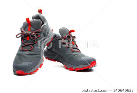 Men trekking shoes isolated on white background. Gray-red hiking shoes. Safety footwear for climbing. Adventure gear. Lightweight rubber trekking shoes with safety sole. Modern and breathable design. Men trekking shoes isolated on white background. Gray-red hiking shoes. Safety footwear for climbing. Adventure gear. Lightweight rubber trekking shoes with safety sole. Modern and breathable design. 140640622