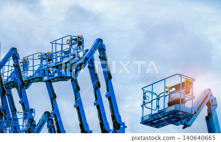 Articulated boom lift. Aerial platform lift. Telescopic boom lift against blue sky. Mobile construction crane for rent and sale. Maintenance and repair hydraulic boom lift service. Crane dealership. Articulated boom lift. Aerial platform lift. Telescopic boom lift against blue sky. Mobile construction crane for rent and sale. Maintenance and repair hydraulic boom lift service. Crane dealership. 140640665