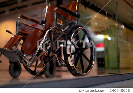 Blurred empty wheelchair near lift in private hospital for service patient and disabled people. Medical equipment in hospital for assistance handicapped people. Chair with wheels for patient care. Blurred empty wheelchair near lift in private hospital for service patient and disabled people. Medical equipment in hospital for assistance handicapped people. Chair with wheels for patient care. 140640666