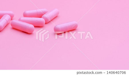 Pink capsule pills on pink background. Vitamin and supplement for healthy skin use in beauty clinic for treatment wrinkle and acne skin. Pharmacy store web banner. Pharmaceutical industry. Happy pill. Pink capsule pills on pink background. Vitamin and supplement for healthy skin use in beauty clinic for treatment wrinkle and acne skin. Pharmacy store web banner. Pharmaceutical industry. Happy pill. 140640706