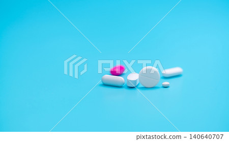 White tablets pills on blur pink tablet pill and blue background. Pharmacy banner. Pharmaceutical industry. Health insurance strategy. Prescription drugs. Polypharmacy and drug interactions problem. White tablets pills on blur pink tablet pill and blue background. Pharmacy banner. Pharmaceutical industry. Health insurance strategy. Prescription drugs. Polypharmacy and drug interactions problem. 140640707