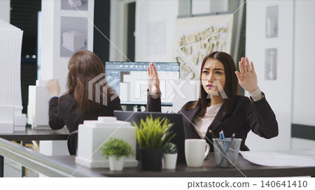 Design specialist using hologram to shape property floor plan, working at a real estate agency, architect developing remodeling project with holographic images, artificial intelligence aid. 140641410