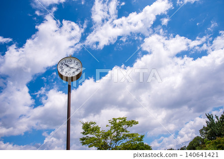 A park clock and white clouds floating in the blue sky A park clock and white clouds floating in the blue sky 140641421