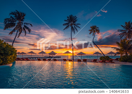 Golden sunset over a tropical lagoon with palm tree silhouettes, sun umbrellas and sunbeds reflected in calm water. Stunning summer travel background. Romantic Maldives beach resort evening scene Golden sunset over a tropical lagoon with palm tree silhouettes, sun umbrellas and sunbeds reflected in calm water. Stunning summer travel background. Romantic Maldives beach resort evening scene 140641633
