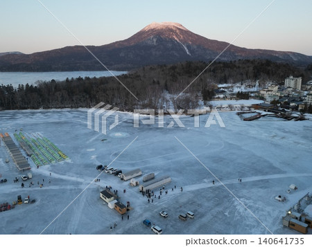 Aerial view of the frozen Lake Akan and Mount Akan at sunset. Aerial view of the frozen Lake Akan and Mount Akan at sunset. 140641735