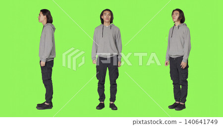 Proud person standing in studio and posing with confidence, acting joyful against full body green screen backdrop, with young smiling man being optimistic and friendly in casual clothes. Proud person standing in studio and posing with confidence, acting joyful against full body green screen backdrop, with young smiling man being optimistic and friendly in casual clothes. 140641749