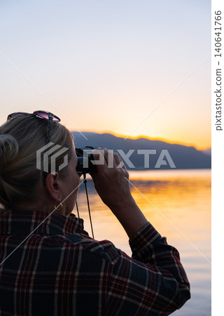Woman Looking Through Binoculars on Marmaris Waterfront at Golden Hour 140641766
