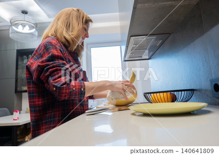 Woman slicing pomelo on cutting board in kitchen, nutritionfocused prep for recipe testing and portioning with knife and plate visible bright light, clean surfaces and attention to texture convey Woman slicing pomelo on cutting board in kitchen, nutritionfocused prep for recipe testing and portioning with knife and plate visible bright light, clean surfaces and attention to texture convey 140641809