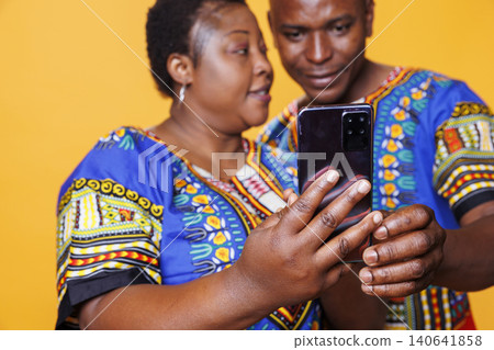 Couple holding smartphone in hand and using application together, with man and woman spouse scrolling social media and reading message on mobile phone closeup. Couple holding smartphone in hand and using application together, with man and woman spouse scrolling social media and reading message on mobile phone closeup. 140641858