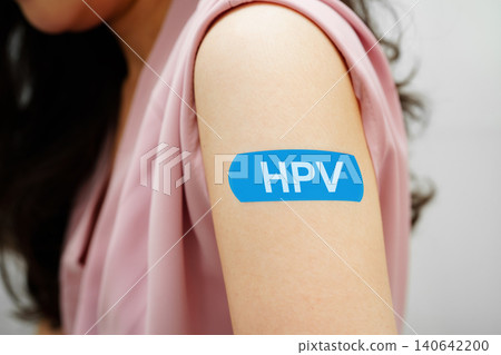HPV, Human papilloma virus, Asian young woman receiving vaccine with blue bandage. 140642200