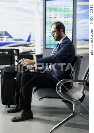 CEO professional, at the airport terminal lounge, global business trip, sitting in waiting area ready for international flight. Consultant seated among passengers traveling by plane. CEO professional, at the airport terminal lounge, global business trip, sitting in waiting area ready for international flight. Consultant seated among passengers traveling by plane. 140642318