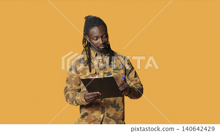 Man looks at checklist on clipboard files, taking notes and preparing with a lot of information on papers, with young man writing something on his weekly organizer, plan survey. Man looks at checklist on clipboard files, taking notes and preparing with a lot of information on papers, with young man writing something on his weekly organizer, plan survey. 140642429