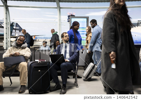 Businessman working on laptop while waiting in busy airport lounge during business trip. Freelancer doing productivity tasks on notebook, enduring long flight layover before next airplane departure 140642542