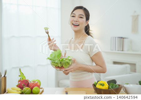 Happy young woman enjoying healthy organic salad at home Happy young woman enjoying healthy organic salad at home 140642594