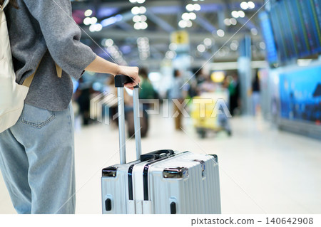 Close up traveler holding suitcase at airport terminal 140642908