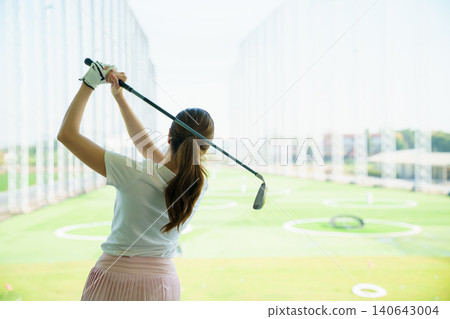 Woman golfer at driving range. Confidence practice and focused golf training. Woman golfer at driving range. Confidence practice and focused golf training. 140643004