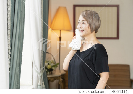 Senior woman stretching in the living room 140643343