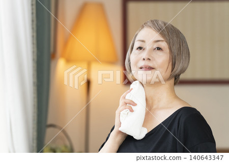 Senior woman stretching in the living room 140643347