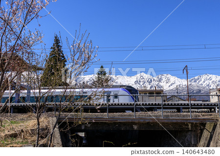 A local train line with the Hakuba mountain range in the background. A local train line with the Hakuba mountain range in the background. 140643480