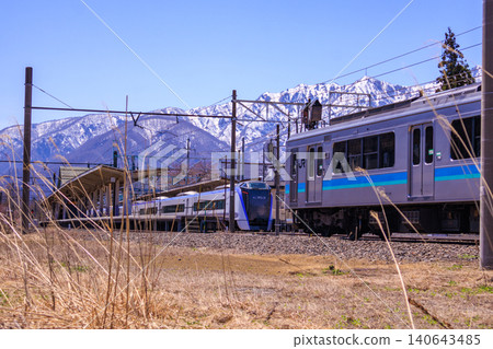 A local train line with the Hakuba mountain range in the background. A local train line with the Hakuba mountain range in the background. 140643485