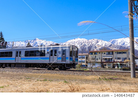 A local train line with the Hakuba mountain range in the background. A local train line with the Hakuba mountain range in the background. 140643487
