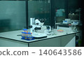 Stereo Microscope on Laboratory Workbench with Test Tubes, Pipette Tips, and Scientific Equipment 140643586