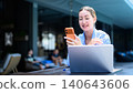 Cheerful digital nomad woman having a video call or seeing good news on phone 140643606