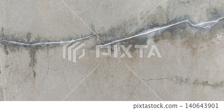 Close-up image of a weathered concrete wall showing long horizontal cracks, damp spots and signs of aging. Close-up image of a weathered concrete wall showing long horizontal cracks, damp spots and signs of aging. 140643901