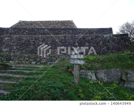 在鳥取縣米子城遺址宏偉的石牆前,一塊路標指示遊客前往「天守閣遺址、內禪丸遺址和二之丸遺址」。 在鳥取縣米子城遺址宏偉的石牆前,一塊路標指示遊客前往「天守閣遺址、內禪丸遺址和二之丸遺址」。 140643949