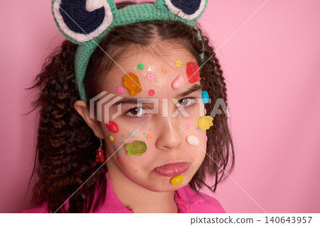 Whimsical Portrait of a Girl with Candy and Surprised Expression Against a Pink Background 140643957