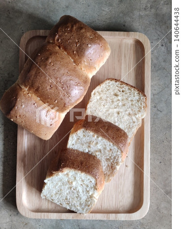 Freshly Sliced White Bread Loaf Pieces Arranged in Wooden Tray for Breakfast, Bakery Serving, or Homemade Meal Preparation 140644438