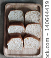 Freshly Sliced White Bread Loaf Pieces Arranged in Wooden Tray for Breakfast, Bakery Serving, or Homemade Meal Preparation 140644439