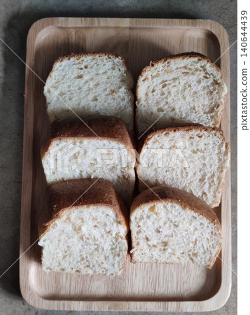 Freshly Sliced White Bread Loaf Pieces Arranged in Wooden Tray for Breakfast, Bakery Serving, or Homemade Meal Preparation 140644439