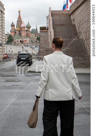Woman in white blazer walks near Bolshoy Moskvoretsky Bridge in Moscow, Saint Basils Cathedral. Travel experience, sightseeing route, cultural heritage, city exploration, tourism content Woman in white blazer walks near Bolshoy Moskvoretsky Bridge in Moscow, Saint Basils Cathedral. Travel experience, sightseeing route, cultural heritage, city exploration, tourism content 140644453