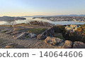 A spectacular panoramic view of the calm waters of Lake Nakaumi and the cityscape stretching out on the opposite shore, as seen from the castle tower base of Yonago Castle. 140644606